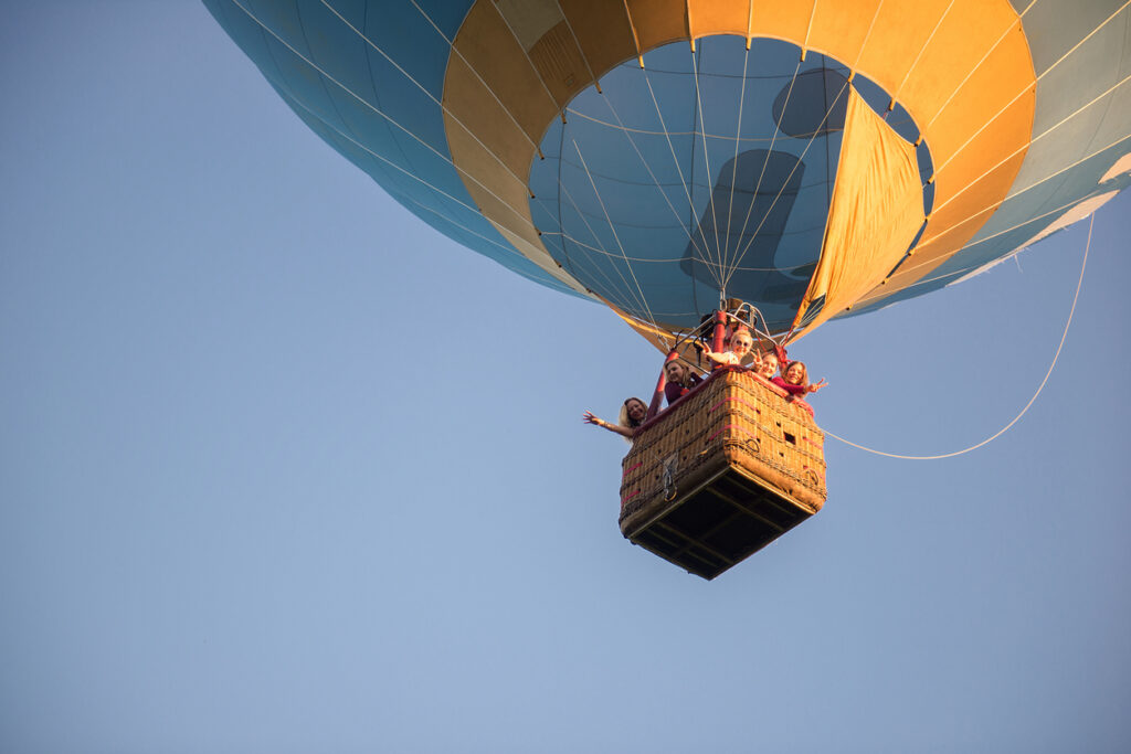 family in hot air balloon against clear sky